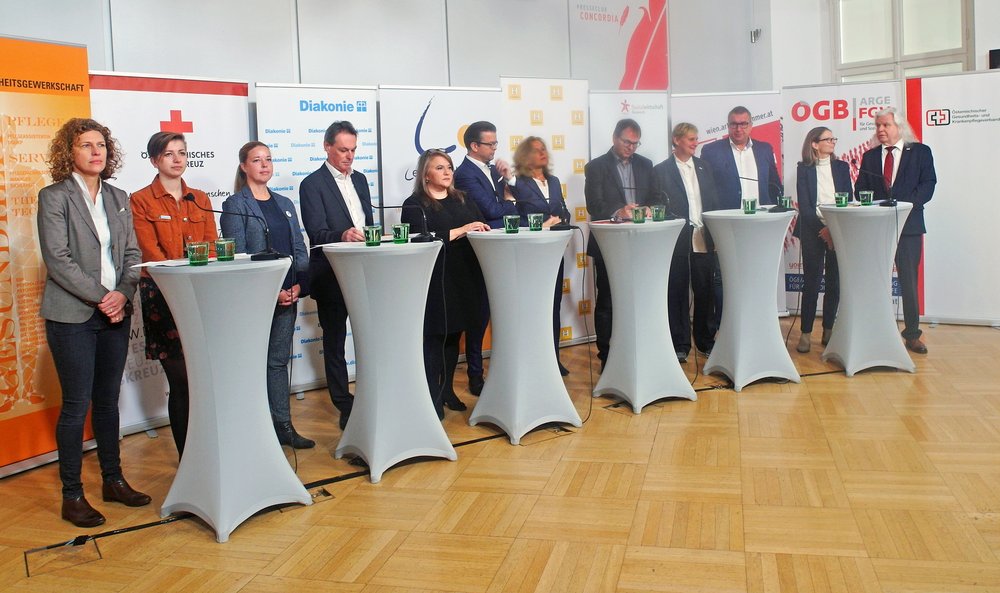Gruppenfoto: VertreterInnen von Arbeitgeber-, Dach- und Berufsverbänden, Trägerorganisationen und ArbeitnehmerInnen-Seite bei der Pressekonferenz; 