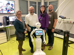 Foto der KollegInnen in Graz gemeinsam mit dem sozialen Roboter Pepper;